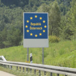 Cesta autom do Rakúska po rakúskej diaľnici s horskou krajinou v pozadí.