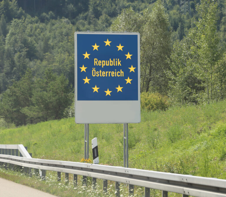 Cesta autom do Rakúska po rakúskej diaľnici s horskou krajinou v pozadí.